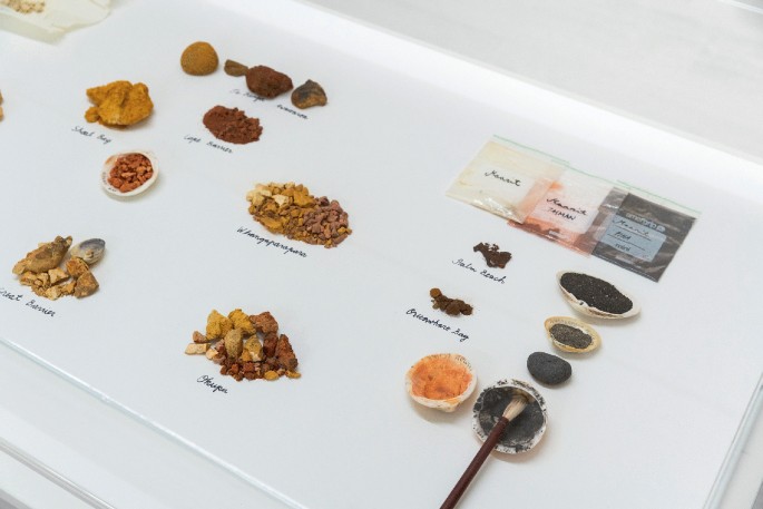 A photograph illustrates an array of soil materials pasted on a sheet. It includes shells, palm beach soil, and pebble.