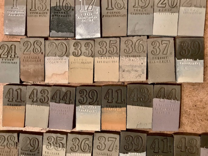 A photograph illustrates the test pieces made of Finnish earthenware clay and dipped in processed soil samples. It includes the numbers and cravings on each tile.