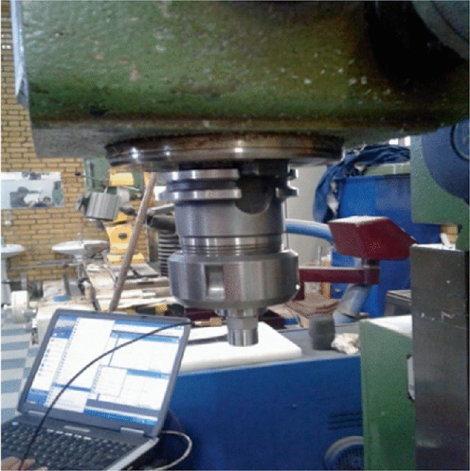 A photograph of the milling machine with a laptop beside it.