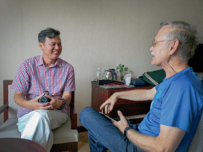 A photograph of a conversation between William Brown and villager Chen Qiaodi in Yangshuo.