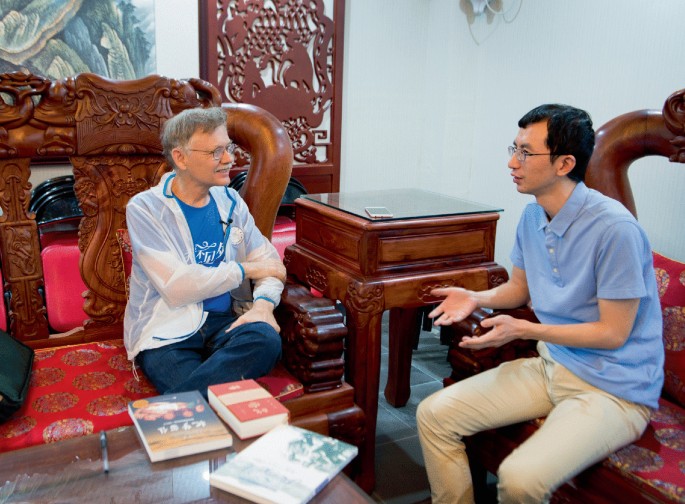 In a photograph, teacher Ye Nan in Beijing is interviewed by professor William Brown.