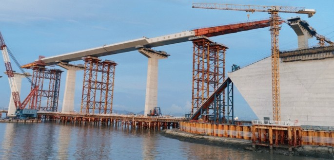 A photograph in side-view of a steel box girder in construction.