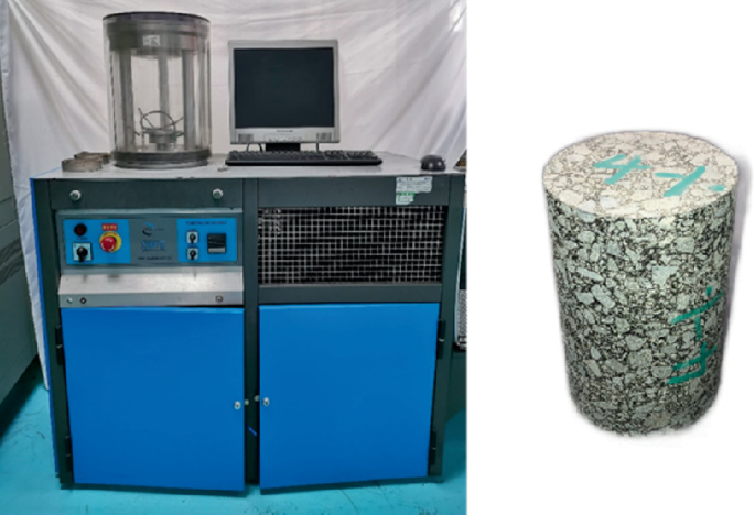 A photograph of the A M P T equipment on the left resembles a cupboard with 2 sections. It includes control buttons, a monitor, a keyboard, and a cylinder to hold the specimen. A close-up photo on the right has a cylindrical piece of asphalt mixture with markings.