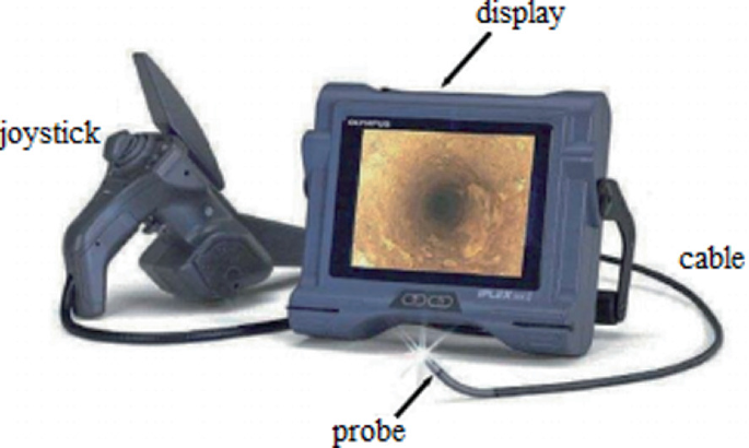 An image of a device that consists of a joystick, a monitor with a display, and a probe attached to a cable.