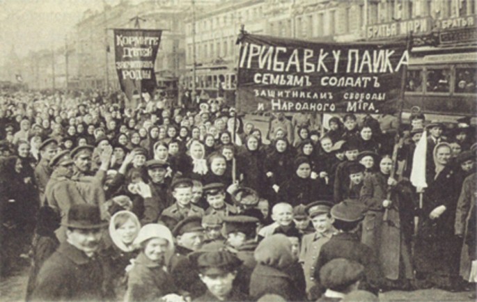 A photograph of men and women gathered at a place with placards in their hands.
