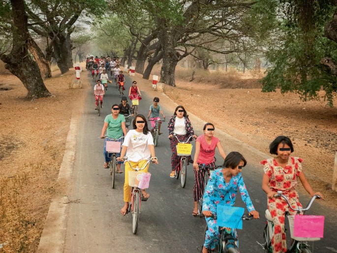 A photograph of a group of women riding bicycles as protest. The cycle baskets have hand written posters.