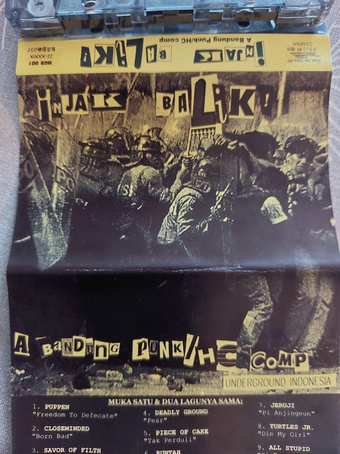 A cover photo of a cassette. It has a photo of the police clashing with the punk group. Text in foreign language.