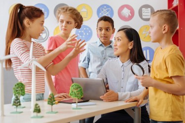 Schoolchildren sharing their ecology project idea with their teacher while she is listening attentively to the group leader. © © yacobchuk / iStock / Getty Images Plus