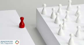 A small red board games piece is separated from a group of white games pieces