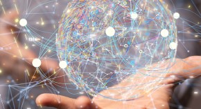 Close-up of the torso of a person as if offering an object with their hand forward - the object is a rendered image of a sphere of connected dotes representing information