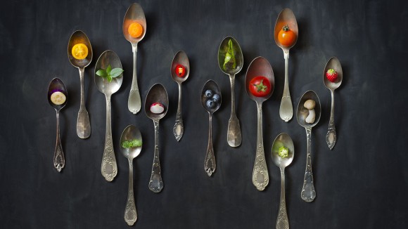 fruit and vegetables laid out in metal spoons