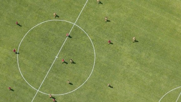 An aerial view of players running on a soccer pitch