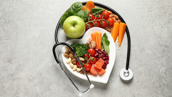 Flat lay composition with plate of products for heart-healthy diet on grey background