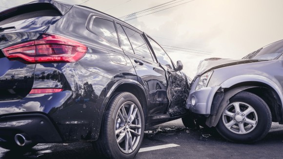 A car crash scene.  Two cars colliding with each other, side-on.