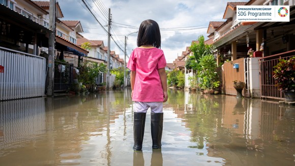 A girl watching a flood on a village road