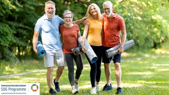 Group of happy senior people with fitness mats in hands posing outdoors