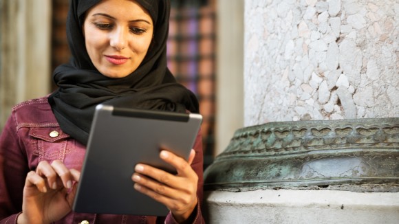 Smiling female looking at tablet device