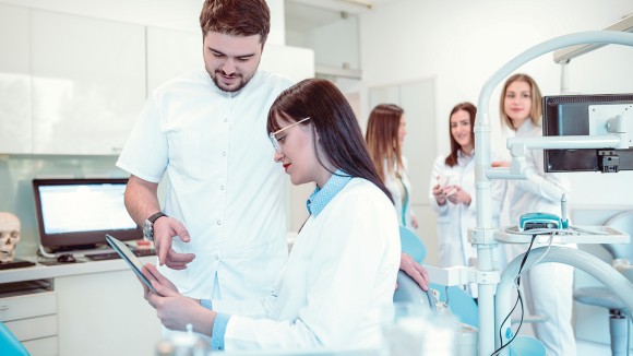 Dental colleagues in dental surgery examining clipboard