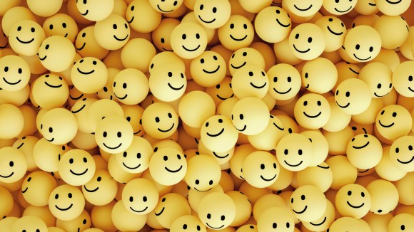 Large group of yellow balls with smiley emoji faces on