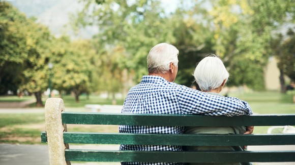 Rearview shot of a senior couple relaxing together on a park bench