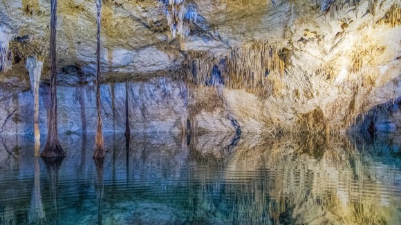Subterranean view of a sinkhole or Cenote in Riviera Maya, Yucatán Peninsula, Mexico. A cenote is a natural pit, or sinkhole, resulting from the collapse of limestone bedrock that exposes groundwater underneath. 