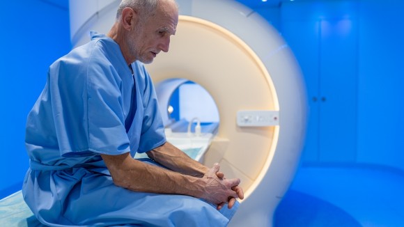 Man sat on edge of MRI scanner