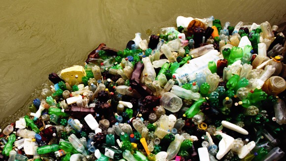 Photograph of a dense patch of plastic bottles and other trash floating on top of greenish-brown water.