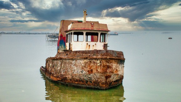 Abandoned ship moored in sea.