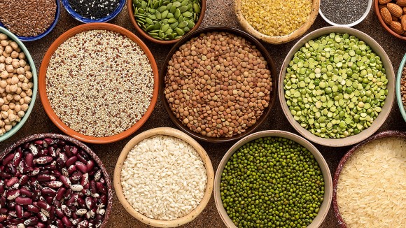 Assorted of a various of legumes, beans, grains and seeds in bowls, banner. Top view, flat lay, border.