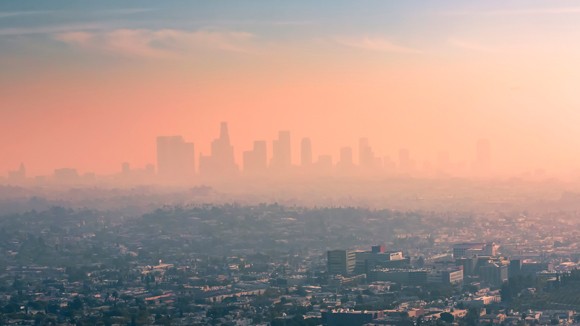 hazy aerial view of a city with sky scrapers behind a pink mist