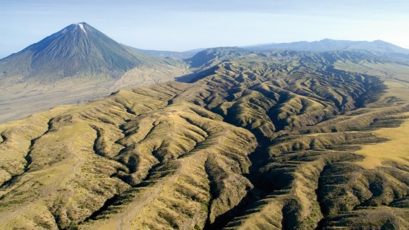 An aerial image of Ol Doinyo Lengai volcano and eroded rift valley gullies, at the Great Rift Valley, Tanzania