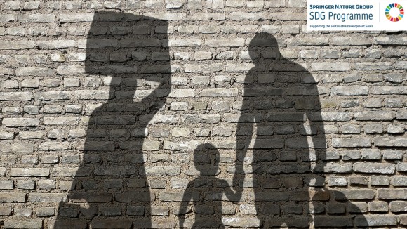 Image showing the shadows of three people, a child and two adults silhouetted on a brick wall.