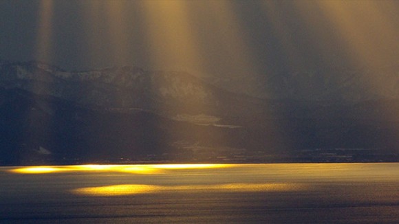 Sunspots on the water with mountains behind