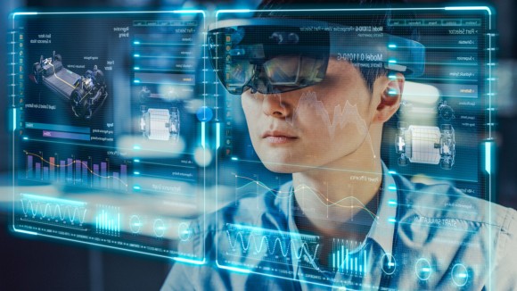 Industrial Factory Chief Engineer Wearing AR Headset Designs a Prototype of an Electric Car Chassis on the Holographic Projection Blueprint. Futuristic Virtual Design of Mixed Technology Application.
