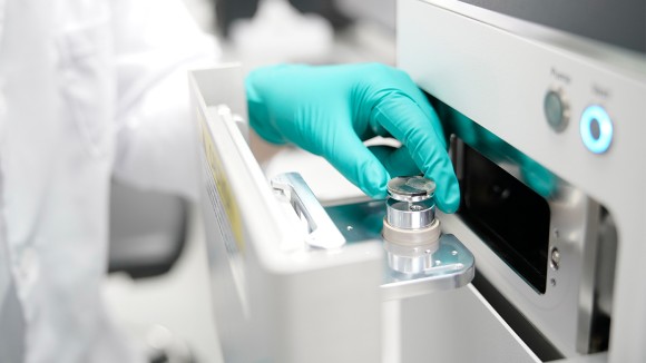 The researcher is loading a fragment of carbonaceous chondrite into the electron microscope to analyse its petrography and mineralogy.