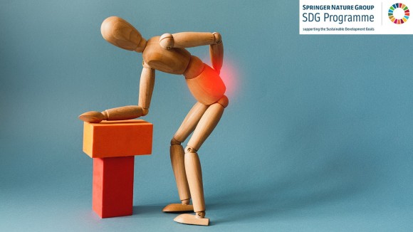 A wooden figure leaning over holding its back, meant to represent the concept of back pain.