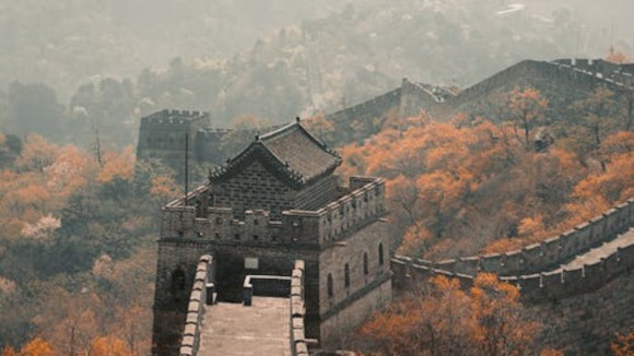 Great Wall Of China on a foggy autumn day. The leaves on the trees have turned red.