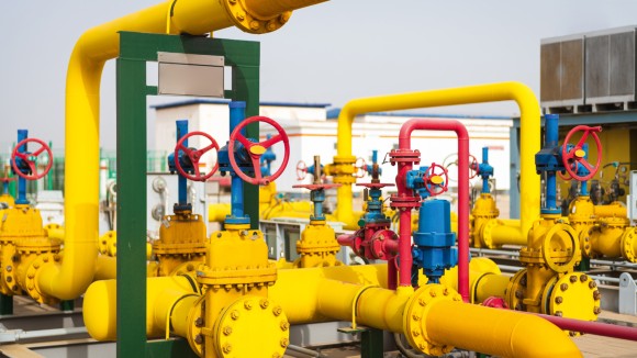 Yellow, blue, and red industrial pipework featuring red control handles. 