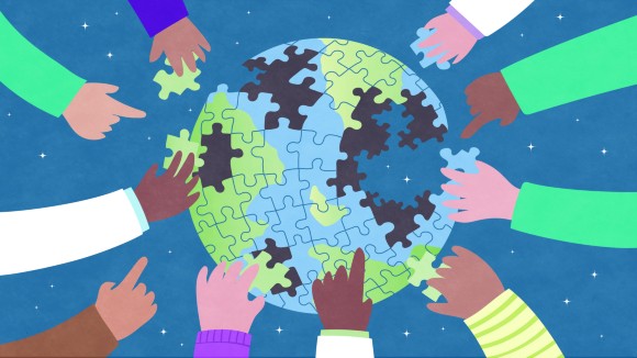 Hands putting together a jigsaw puzzle of the world