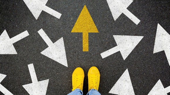 Different thinking and Business and technology disruption concept. Yellow big arrow opposite direction with white arrow on road asphalt. Standing out from the crowd