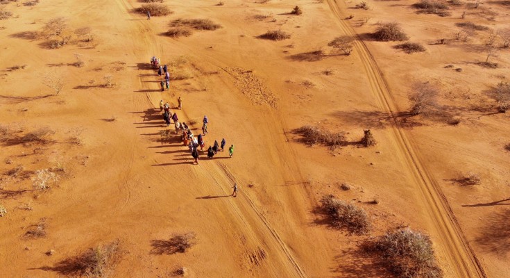 Birds-eye view of a group of people walking along desert land in Somalia