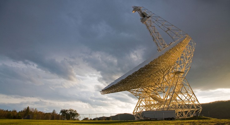 A radio telescope against a cloudy sky