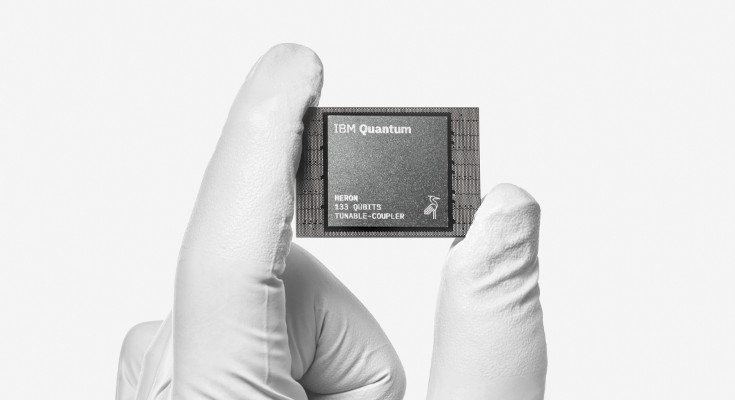 A white-gloved hand holding an IBM Quantum chip