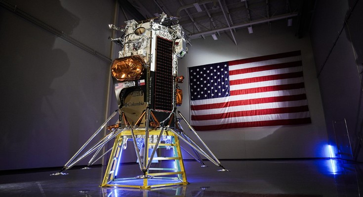 A small shuttle in front of an American flag