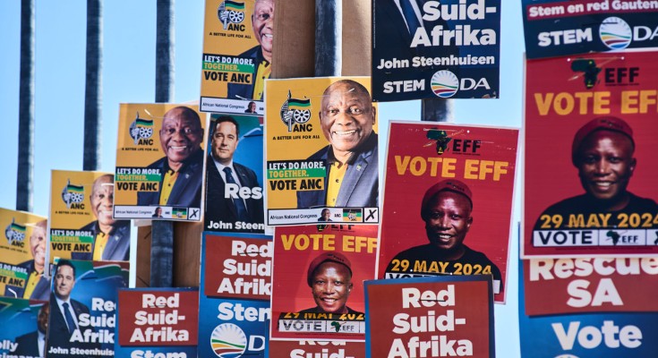 A fence is covered in election posters, some for the African National Congress, some for Red-Suid Afrika, some for EFF