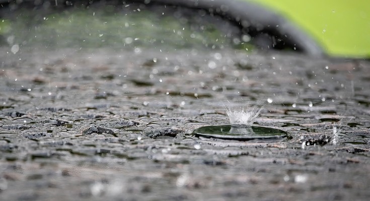 Heavy rainfall on the ground, with water droplets splashing back up