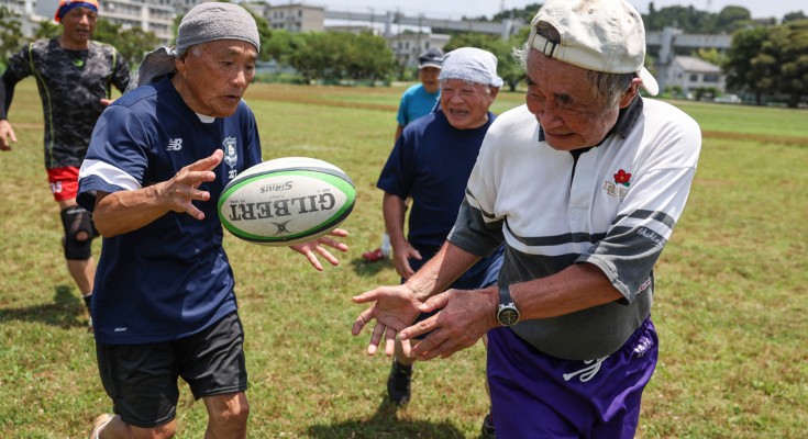 A group of elderly men play rugby
