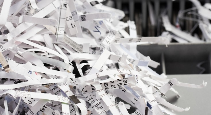 A pile of shredded paper with black printed text on