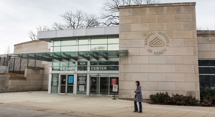 A lone woman pictured outside the entrance to the NIH Campus in Bethesda, Maryland