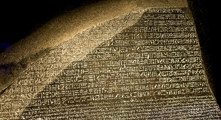 A replica of the Rosetta Stone showing the top portion of the stone with ancient Hieroglyphs followed by Demotic script.